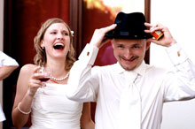 Panna młoda śmieje się radośnie patrząc na swego męża zakładającego kapelusz - zdjęcie z wesela, Łódź. Agata-Pawel-2010-07-03-772