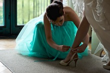 fotografia ślubna - reportaż z przygotowań - siostra pomaga pannie młodej zapiąć pantofel przed ślubem Iza-i-Kacper-przyg-106