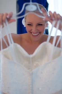 kreatywna fotografia ślubna - panna młoda cieszy się patrząc na suknię ślubną Marta-Cyrille-2011_07_30-0082